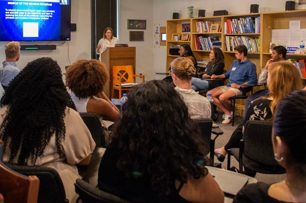 IMHS students listen to Dr. Amri in a classroom during orientation.